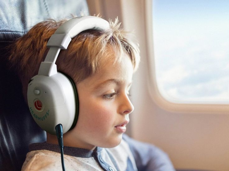 casque anti-bruit blanc sur un enfant dans un avion  Image